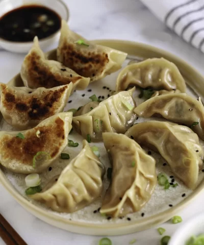 Chinese pork dumplings picking up a dumpling with chopsticks 720x997 2
