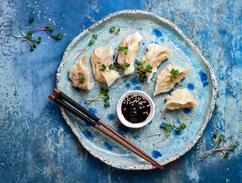 asian dumplings soy sauce sesame seeds microgreens traditional chinese dim sum copy space flat lay chopsticks 102566081